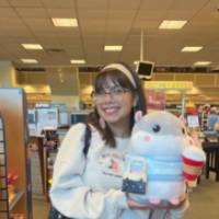 Female student standing in a store holding stuffed animal